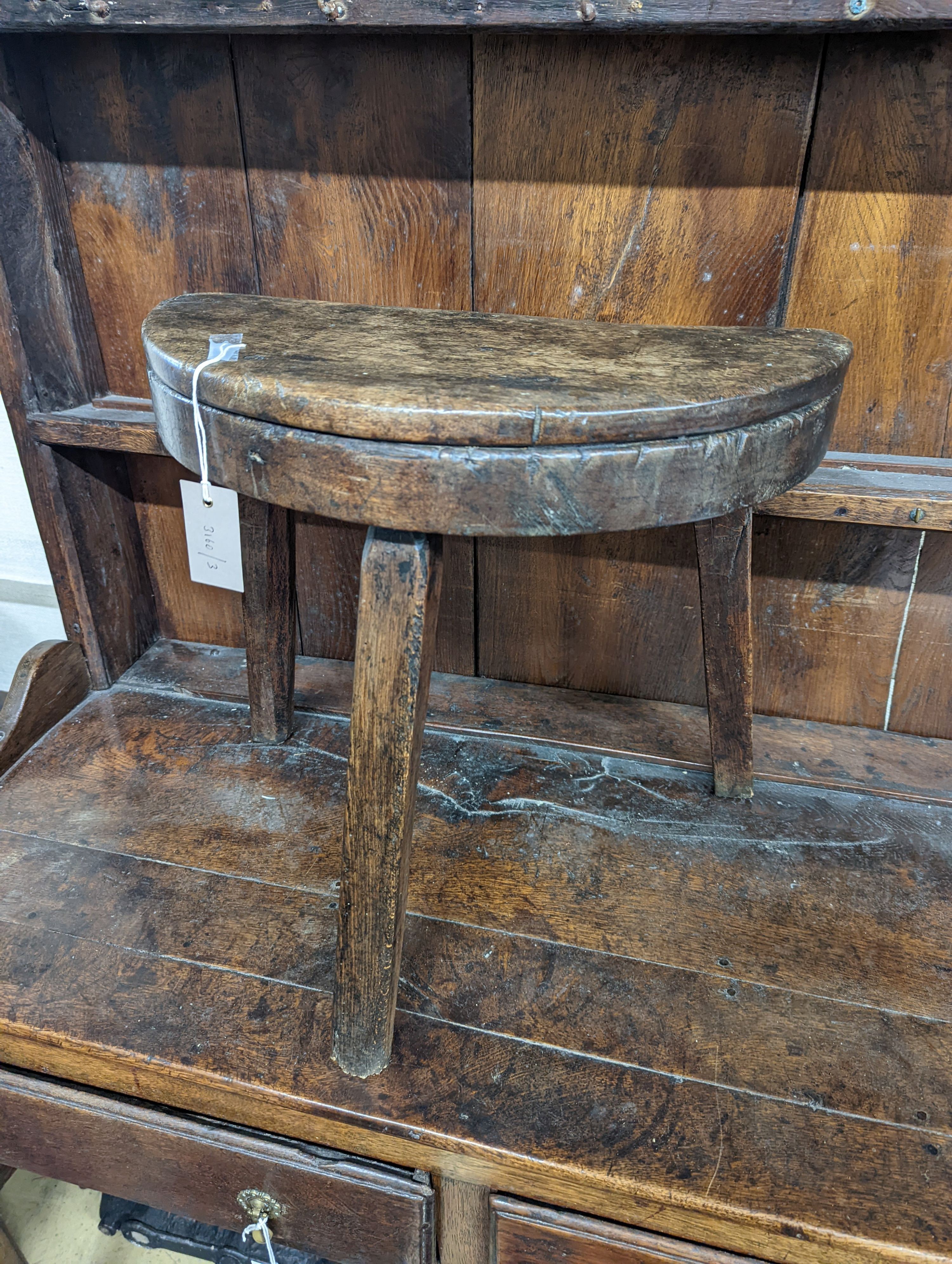 A 19th century primitive fruitwood stool. W-47cm, D-22cm, H-45cm.